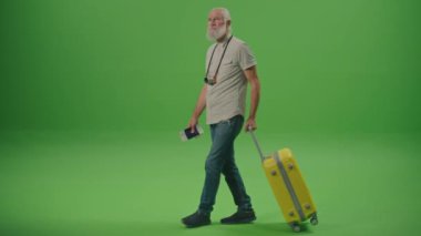 Yeşil Ekran. Sarı bir bavulla yaşlı bir erkek turist yürüyor ve biletlerini kontrol ediyor. Yaşlı bir adam skor tabelasında tam kalkış zamanını arıyor. Yaşlılar için Bütçe Seyahati.
