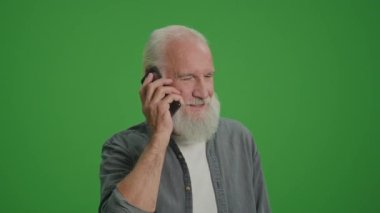 Yeşil Ekran. Gri sakallı, gülümseyen yaşlı bir adam telefonda konuşuyor. Kıdemli Teknoloji Kullanıcıları için Güvenlik ve Gizlilik Endişeleri. Yaşlılar için Gelişen Teknolojiler.