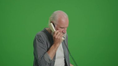 Yeşil Ekran. Gri Sakallı Yaşlı Adam Birisiyle Eski Telefon ve Quarrels Konuşuyor. Eski Telefonları Topluyor ve Koruyor.