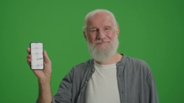 Yeşil Ekran. Akıllı telefonlu gülümseyen yaşlı bir adamın portresi. Yaşlılar için Gelişen Teknolojiler. Market Evleri ve Yaşlılar İçin Şeyler İnterneti.