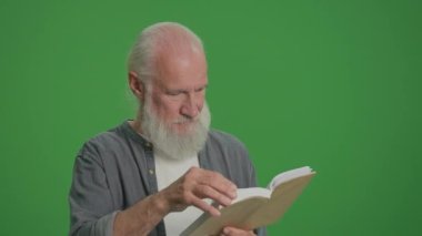 Yeşil Ekran. Kitap okuyan, gri sakallı, zeki bir ihtiyarın portresi. Yaşlı bir adam bir kitabın sayfalarını karıştırır. Boş zaman, Hobi Konsepti.