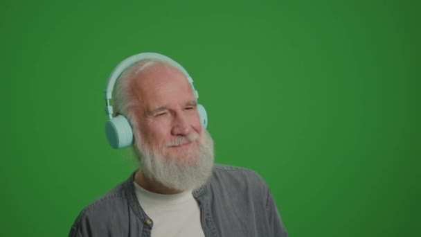 Zöld Vászon Egy Boldog Öregember Szürke Szakállal Zenét Hallgat Fejhallgatón — Stock videók