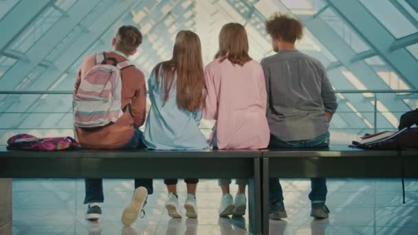 Vista Posteriore Degli Studenti Seduti Sulla Panchina Nel Corridoio Universitario — Video Stock