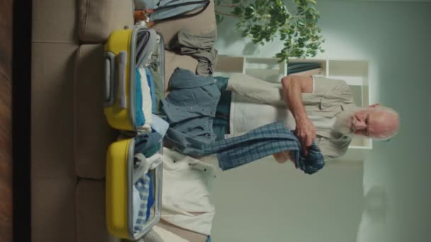 Vertikale Ansicht Ein Lächelnder Reisender Alter Männer Sammelt Kleidung Für — Stockvideo