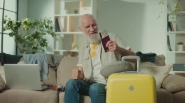 Komik Gözlüklü Gülümseyen Yaşlı Adam, Geleceğe Yolculuğu Hakkında Mutlu. Uçak biletlerini ve pasaportunu öpen mutlu yaşlı bir adam. Seyahat Belgeleri Hazırlama. Sağlık Çekilmeleri.