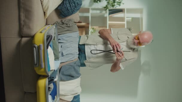 Vertical View Smiling Old Man Traveler Gathers Clothes Trip Dancing — Stock Video
