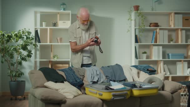 Ein Lächelnder Reisender Alter Männer Sammelt Kleidung Für Eine Reise — Stockvideo