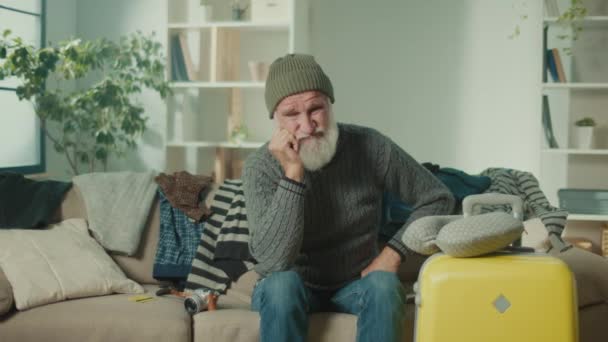 Ein Enttäuschter Alter Mann Mit Koffer Sitzt Auf Dem Sofa — Stockvideo