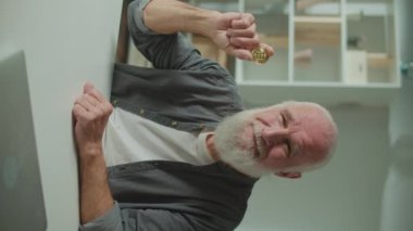 Dikey Bakış. Başarılı Yaşlı Serbest Adam 'ın Portresi Evinde Altın Btc Madeni Paralar Tutuyor. Yaşlı Adam Elde Bir Bitcoin Tutuyor. Yaşlı Nesiller için Kripto Para.