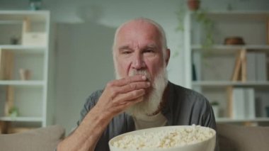 Patlamış mısır yiyen ve televizyon seyreden yaşlı bir adam. Kanepede oturan ve çok ilginç bir film izleyen ciddi bir yaşlı adam. Sinema ve Rolü.