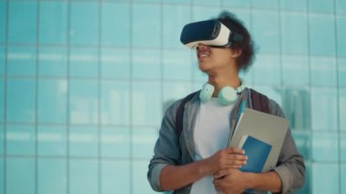 Üniversitenin arka planında VR kulaklık takan motive olmuş genç bir öğrenci. Sanal Gerçeklik Öğrenme Konsepti. Dijital Eğitim. Eğitimde yenilikler. Gelecek Teknolojileri