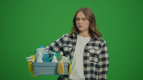 绿色屏风 一位戴黄色橡胶护目镜的严肃年轻女士拿着装有清洁剂的盒子 检查清洁剂的用量 — 图库视频影像