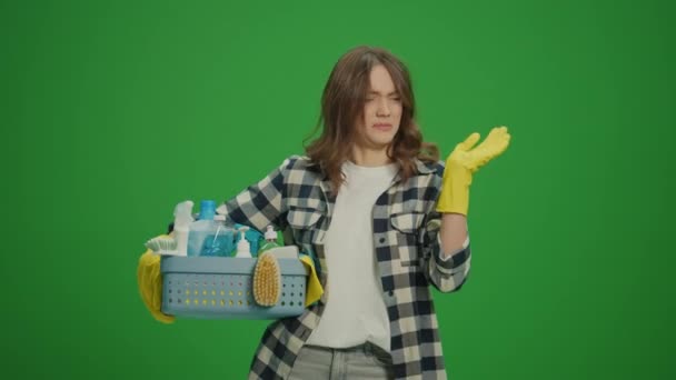 绿色屏风 一个穿着黄色手套的年轻女人拿着装有清洁用品的盒子 闻到难闻气味的画像 方便宠物的清洁方法 — 图库视频影像