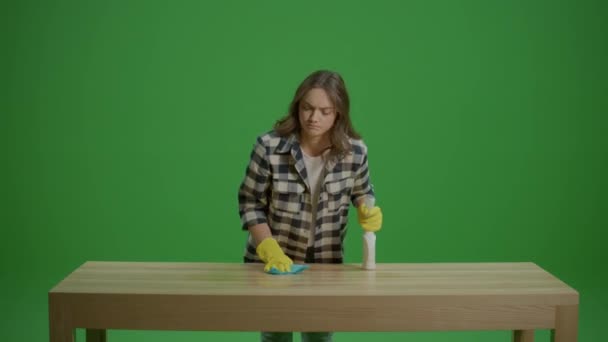 一个愤怒疲惫的年轻女人戴着黄色的橡胶护目镜 拿着喷雾器 擦桌子 多功能清洁工具 — 图库视频影像