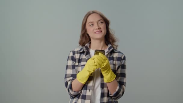 Μια Χαμογελαστή Νεαρή Γυναίκα Νοικοκυρά Κίτρινα Γάντια Γραπτών Μηνυμάτων Κάποιον — Αρχείο Βίντεο