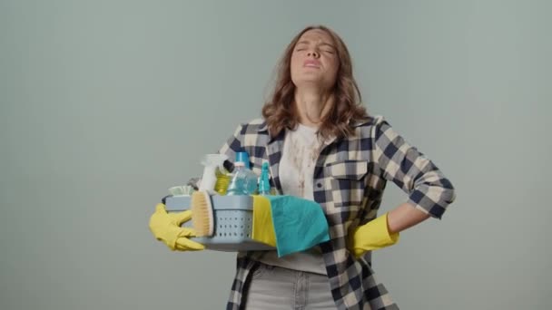 汚れたUpset怒っている若い女性の主婦 黄色い手袋 クリーニング プロダクトが付いている箱を握って 灰色の背景で運びます バーチャルクリーニングコンサルティング — ストック動画