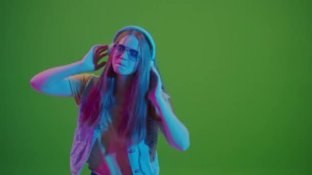 Yeşil Ekran Neon Işıklarla Dans Eden Genç Kız Kulaklıklarından Müzik — Stok video