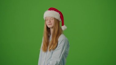 Yeşil Ekran. Noel Baba Şapkalı Kız Heyecanla Noel Hediyelerini Gösteriyor. Bayram çılgınlığı, mevsimlik alışveriş ve Noel kutlamalarının atmosferi. Tatil Alışveriş Sprei