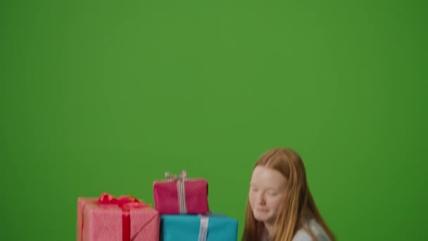 グリーン スクリーン 魅力的な少女は笑顔を身に着け 彼女の手の中のギフト用の箱の弁当を握っています 祝祭の精神を体現し 彼女は特別な母親の喜びと予想を放射する — ストック動画