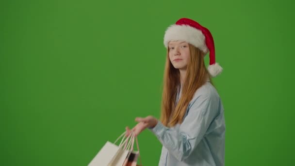 Groen Scherm Meisje Een Kerstman Hoed Toont Enthousiast Haar Kerstaankopen — Stockvideo