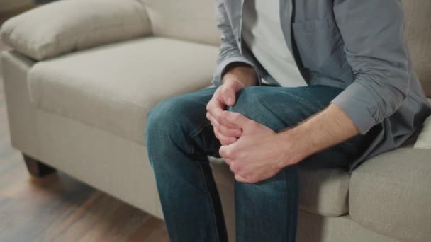 Man Has Kneecap Pain Sitting Sofa Home Feeling Illness Healthcare — Stock Video