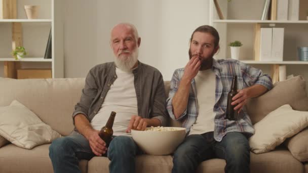 Senior Mladý Přítel Pohovce Popcornem Ruce Podílí Sledování Živých Filmů — Stock video