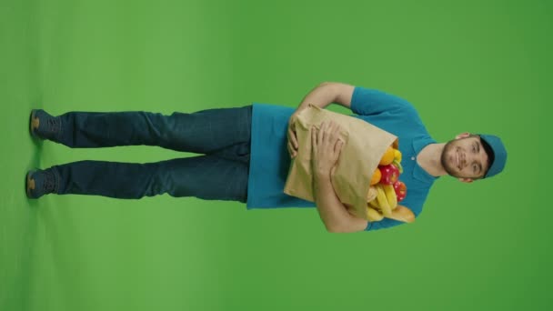 Vertikale Video Green Screen Delivery Man Bringt Papiertüte Mit Lebensmitteln — Stockvideo