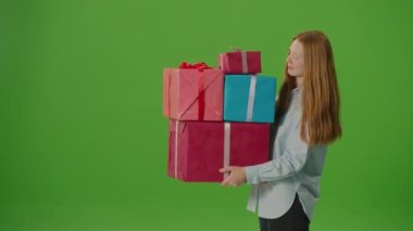 Yeşil ekran. Gülümseyen ve elinde bir sürü hediye kutusu tutan çekici bir kız var. Kutlamanın ruhunu somutlaştırarak, neşe saçar ve özel anların beklentilerini karşılar.