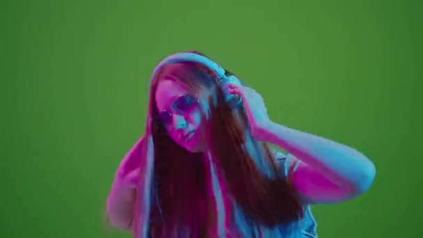 Yeşil Ekran Neon Işıklarda Dans Eden Genç Kız Kulaklıklarından Müzik — Stok video