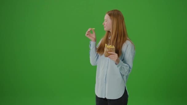 绿色屏幕 金发少女笑着吃薯条 现代趋势 反式脂肪 健康饮食 年轻人的选择 — 图库视频影像