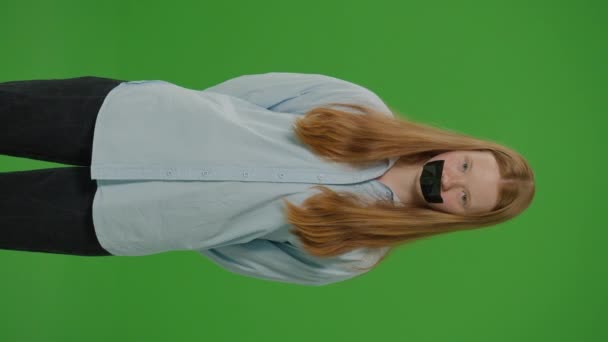 Pantalla Videoverde Vertical Chica Coloca Con Cinta Adhesiva Sobre Boca — Vídeos de Stock