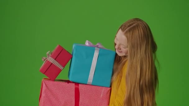 绿色屏幕 迷人的女孩戴着微笑 手里拿着一束礼品盒 她体现了庆祝的精神 散发着欢乐和对特殊时刻的期待 — 图库视频影像