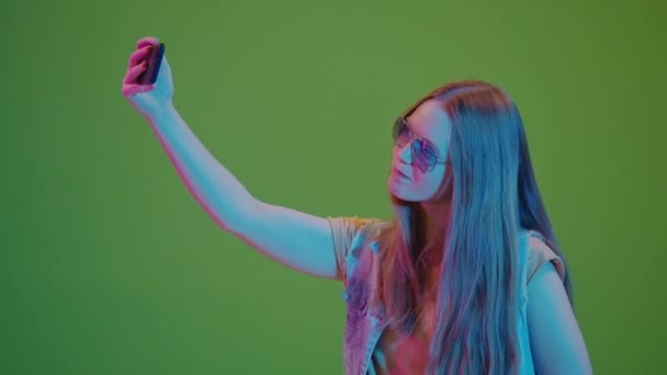 绿色屏风 在霓虹灯中的少女带着自私自利 散发着积极向上和高昂的精神 青年数字文化的现代快照及其生动的个性表现 — 图库视频影像
