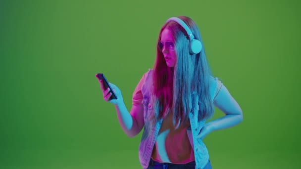 Grön Skärm Tonårstjej Neonljus Medan Surfar Sociala Medier Sin Mobiltelefon — Stockvideo