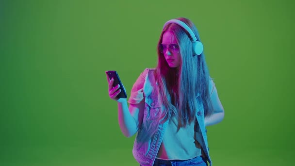 Grön Skärm Tonårstjej Neonljus Medan Surfar Sociala Medier Sin Mobiltelefon — Stockvideo