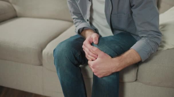 Man Has Kneecap Pain Sitting Sofa Home Feeling Illness Healthcare — Αρχείο Βίντεο