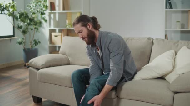 Homem Tem Dor Joelho Sentado Sofá Casa Sentindo Tão Doente — Vídeo de Stock