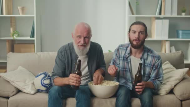 Senior Giovane Compagno Divano Birra Popcorn Mano Profondamente Coinvolti Nei — Video Stock