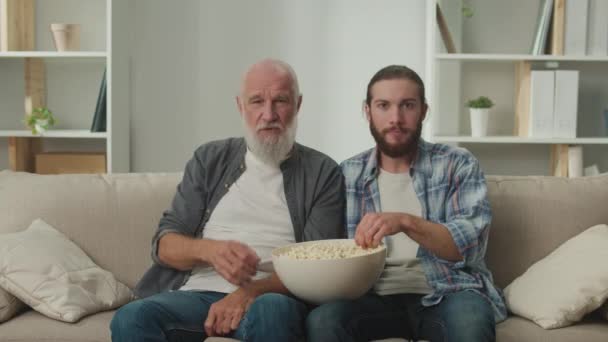 Senior Och Ung Vän Soffan Med Popcorn Sina Händer Involverad — Stockvideo
