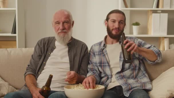 Starszy Młody Przyjaciel Kanapie Popcornem Rękach Zaangażowany Oglądanie Filmów Żywo — Wideo stockowe