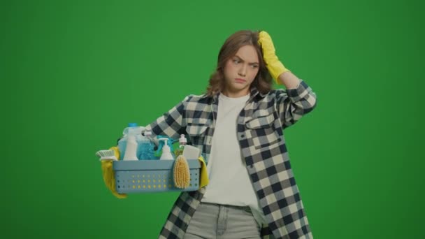 绿色屏风 一位戴黄色橡胶护目镜的严肃年轻女士拿着装有清洁剂的盒子 检查清洁剂的用量 — 图库视频影像