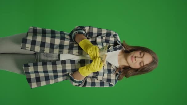 垂直视图 绿色屏幕 一个穿着黄色橡胶护目镜的笑着的年轻女性家庭主妇用美元数钱 有效的家庭外工作环境 — 图库视频影像