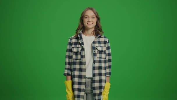 一个穿着黄色手套的笑着的年轻女人的画像 手里拿着一个清洁的喷雾器和一把破布 露出了大拇指和一个好的标志 一位女家庭主妇正准备打扫房间 速度清洗 — 图库视频影像