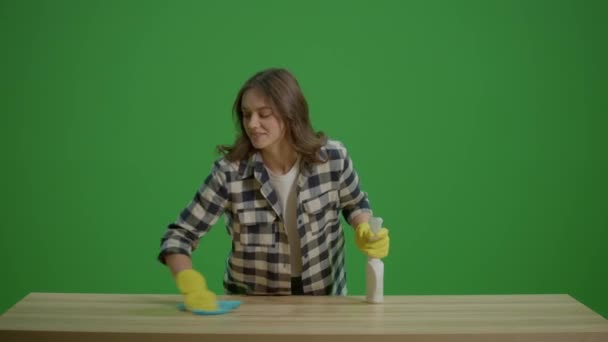 グリーンスクリーン 笑顔の若い女性主婦はスプレーボトルとラブでテーブルを掃除し 喜んでクリーニングします 効率的なワーク ホーム セットアップ — ストック動画