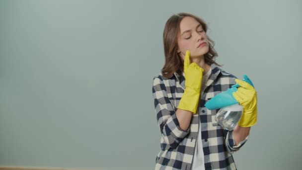 Portret Myślącej Młodej Kobiety Żółtych Rękawiczkach Trzymającej Butelkę Szmatę Sprayu — Wideo stockowe