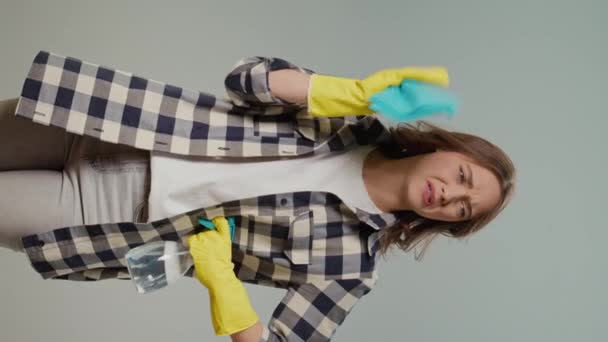 一个穿着黄色手套的年轻女人拿着一块干净的抹布 在灰蒙蒙的背景上闻到一股难闻的气味的画像 宠物拥有人智能家居自动化系统 — 图库视频影像