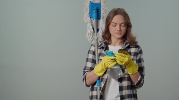 Szczęśliwa Młoda Kobieta Żółtych Rękawiczkach Mopem Butelką Spray Smartfonem Cieszy — Wideo stockowe