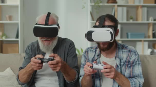青少年和老年人沉浸在虚拟现实游戏中 世代间通过虚拟现实交流经验 利用尖端技术在虚拟现实中进行娱乐 家庭教育和理解 — 图库视频影像