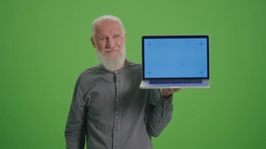 Yeşil Ekran. Dizüstü bilgisayarlı yaşlı bir adamın portresi. Mavi Ekran Başparmağını gösteriyor. Yaşlılar için Dijital Edebiyat ve Teknoloji Eğitimi. Yaşlılar Dijital Teknolojiyi Kucaklıyor.