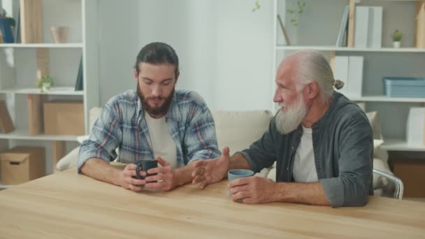 Due Amici Giovane Uomo Più Anziano Sono Seduti Tavolo Discutono — Video Stock